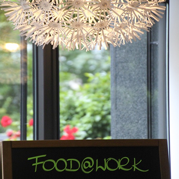Buerocenter Nord Detail Lampe Kantine mit Schriftzug Food&Work im Blick