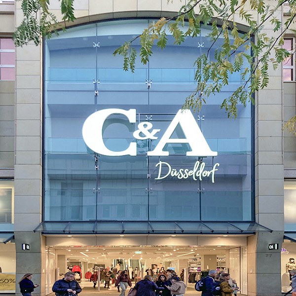 Belebter Eingang C&A Düsseldorf mit Haushoher Glasfront und mannshohem Logo