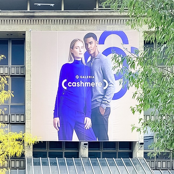 Poster über Eingang Galeria Karstadt mit Werbung für Cashmere-Pullover