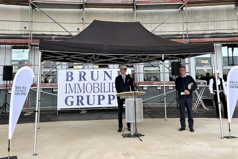 Christopher Brune hält Rede zum Richtfest Gebäude Arcadia Stern vor Brune Banner