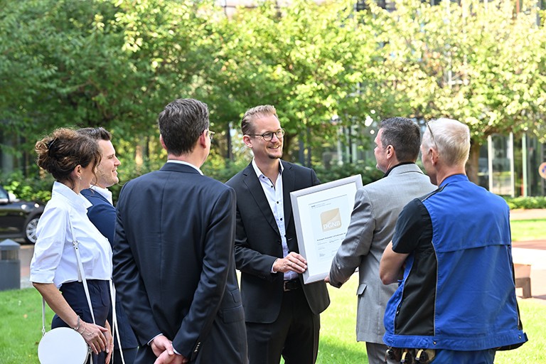 Leiter der DGNB Zertifizierung überreicht Vorstandsvorsitzenden der Brune Real Estate Management AG Christopher Brune feierlich das DGNB-Goldzertifikat