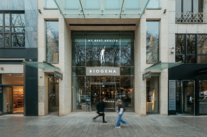 Königsallee 88 Eingang Shop Biogena mit Glasvordach und zwei Passanten davor