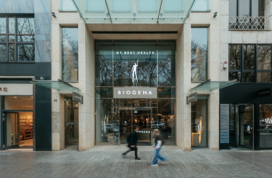 Königsallee 88 Eingang Shop Biogena mit Glasvordach und zwei Passanten davor
